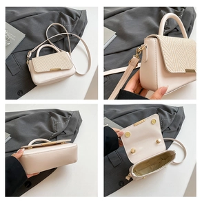 Detail view of cream white crossbody bag featuring herringbone weave texture and magnetic buckles