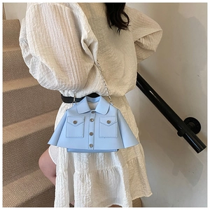 Detail of light blue jacket-shaped chain bag featuring lapels and metal buttons on a model