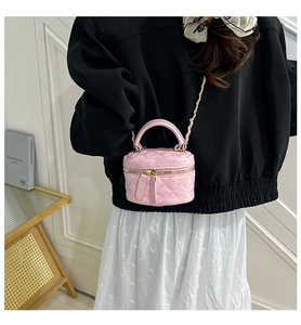 Nahaufnahme einer rosa gesteppten Mini-Tasche mit goldener Kette an einem Model
