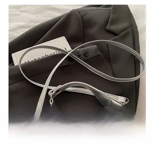 Detail of adjustable strap and lace edge on silver metallic PU dumpling handbag