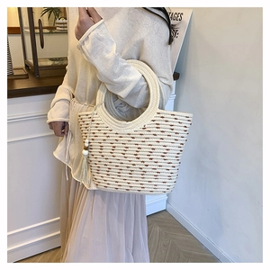 Detail of hand-woven beige tote bag with brown polka dots and wooden bead tassels