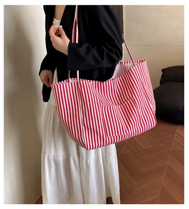 Detail of red and white striped canvas tote bag showing front pocket and large capacity