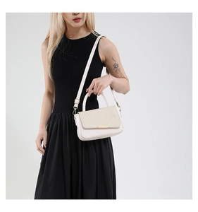 Détail du sac beige avec rabat à chevrons tissé et boucle dorée en barre métallique