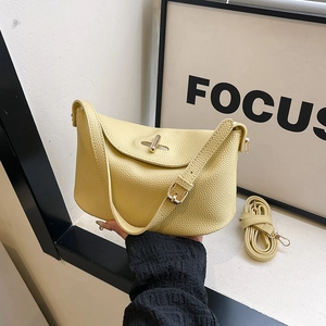 Pale yellow lychee grain leather pillow handbag with metal twist lock and dual straps
