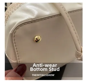 Detail view of the woven bucket bag base with protective gold-toned metal studs