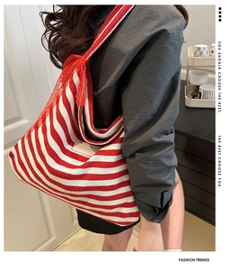 Detailed side view of large red striped canvas tote bag with red lace bow decoration