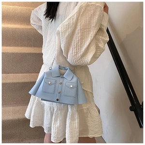 Detail of unique light blue shirt-shaped crossbody bag with silver chain and metal buttons