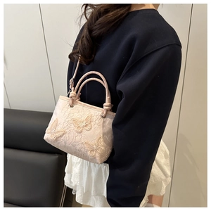 Detail view of mini water bucket bag featuring 3D butterfly embroidery and lace texture