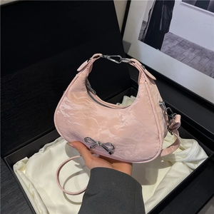 Sac hobo rose avec nœud argenté présenté dans un coffret cadeau élégant