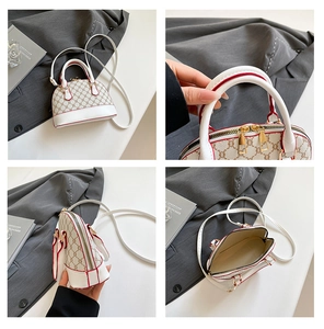 Macro detail of white shell bag with monogram print, red edges and golden dual zippers