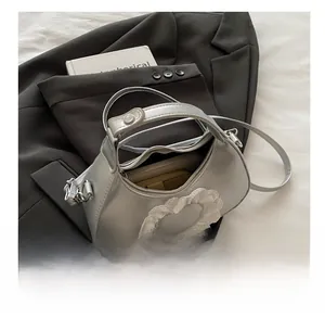 Internal storage view of silver heart saddle bag holding phone and long wallet