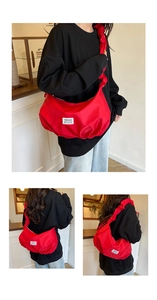 Detailed view of red pleated crossbody bag with thick ruched strap and fashion label
