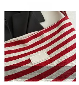 Close-up of red and white striped tote bag with woven herringbone texture details