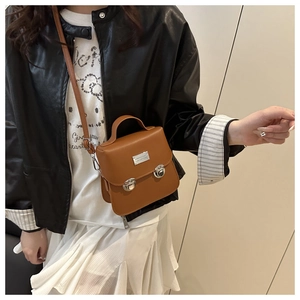 Dettaglio borsa a secchiello vintage in pelle marrone con fibbie metalliche argentate