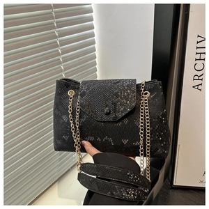 Gros plan sur un sac à bandoulière en peau de serpent noire avec chaîne dorée élégante