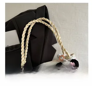 Detail of woven rope handles and cute panda pendant on white textured tote bag
