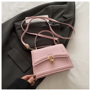 Detailed top view of pink leather crossbody flap bag with gold interlocking buckles