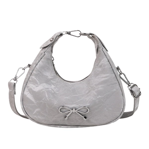 Silver crescent bow handbag with metallic crinkled finish and adjustable shoulder strap