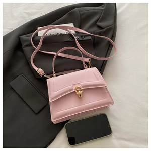 Detail view of pink leather handbag with gold buckle and textured lines on gray suit background