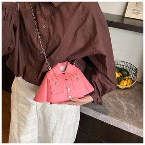 Close-up of a pink leather jacket-shaped crossbody bag with silver chain and button detail