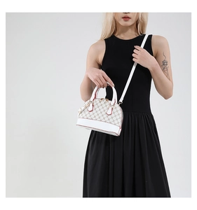 Close-up of shell dome bag featuring monogram pattern and red edge finishing detail