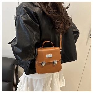 Rear view of a model wearing a caramel brown leather crossbody bucket bag in a street style set