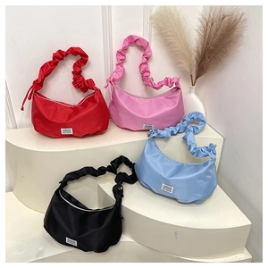 Detail view of colorful nylon dumpling bags with trendy ruched shoulder straps