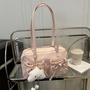 Pink large shoulder bag with bow details and cloud charm on a minimalist shelf