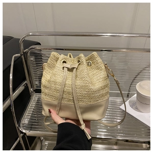 Detail of off-white straw bucket bag featuring drawstring closure and premium texture