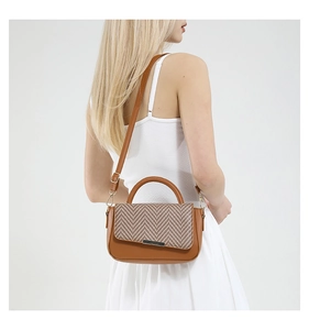 Détail du sac à main marron avec rabat à chevrons texturé et bandoulière en cuir souple