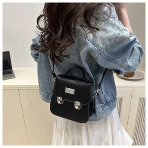 Vue détaillée d'un petit sac bandoulière rétro noir avec boucles argentées et poignée