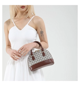 Macro detail of retro shell handbag showing brown leather trim and golden zipper hardware