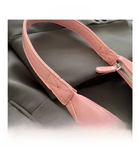 Detail of pink leather handbag showing reinforced shoulder strap stitching and silver zipper