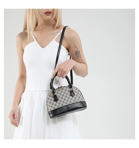 Detailed view of the shell-shaped crossbody bag with grey jacquard and black leather trim