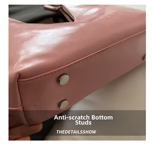 Detailed macro view of pink leather handbag bottom with protective metal studs