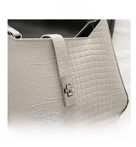 Close-up of white crocodile and snake texture handbag with silver metal swivel lock