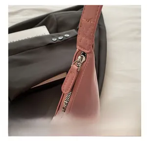 Close-up of smooth silver metal zipper and pink glossy leather on a fashion shoulder bag
