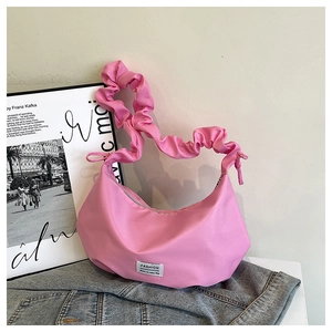 Détail du sac plissé rose avec étiquette FASHION sur fond de veste en jean bleu clair