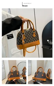 Detail view of brown shell bag with triumph monogram pattern and adjustable strap