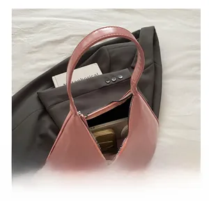 Pink glossy hobo bag interior showcasing capacity for wallet and notebook