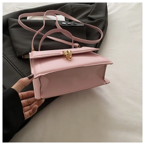 Detailed shot of pink leather crossbody bag with elegant gold metal twist lock