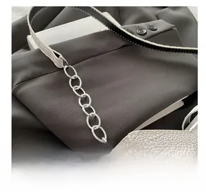 Detail shot of silver circular metal chain link and white crocodile texture leather