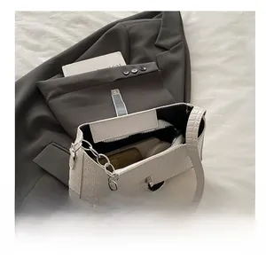 Detail showing white crocodile pattern handbag interior capacity for cosmetics and wallet