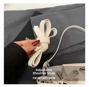 Détail de la bandoulière réglable en cuir blanc avec crochet pivotant en métal