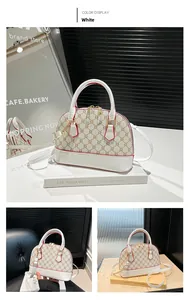 Detail of shell-shaped white leather bag with monogram pattern and red edge finishing