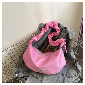 Détail du sac croissant rose avec bandoulière plissée élégante et étiquette fashion