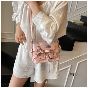 Détail du sac à bandoulière rose en similicuir avec décoration nœud et fermoir métallique