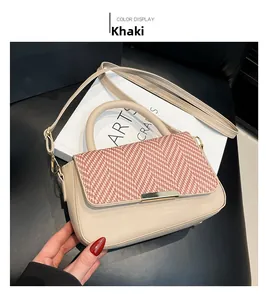 Vue détaillée du sac à bandoulière kaki avec rabat tissé à chevrons roses et boucle dorée
