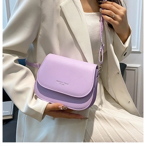 Detail of lavender crossbody bag featuring embossed fashion text on matte PU leather