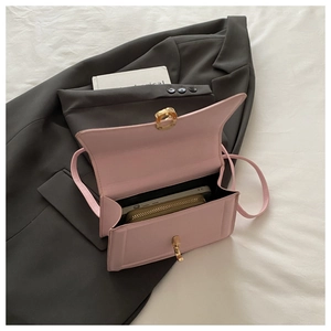 Detail of light pink crossbody bag interior showing storage space for phone and wallet